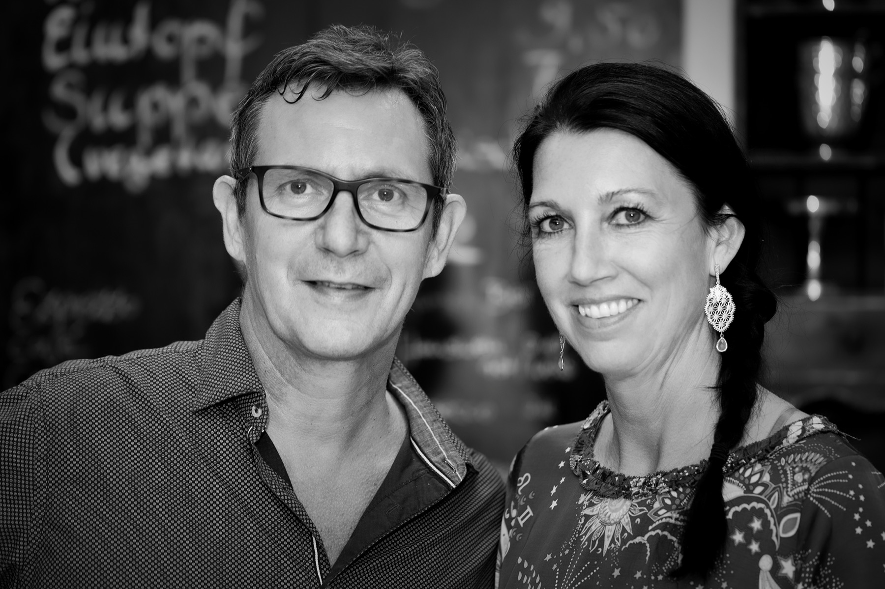 Helmut Baldauf und Andrea Thuli vor der Kreidetafel im Café